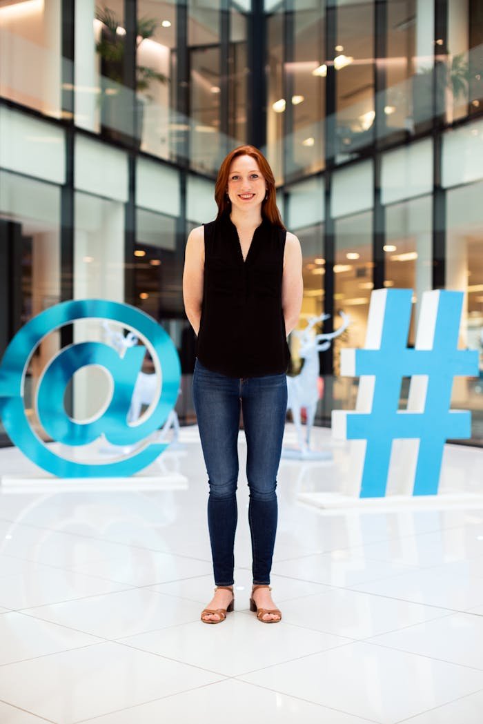 Woman In Black Sleeveless Shirt And Blue Denim Jeans Standing On White Floor Tiles